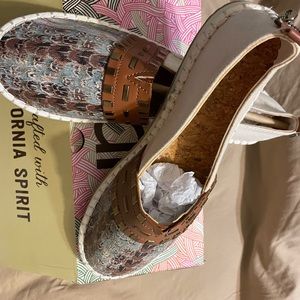 The shoes have a feather print on top with green brown and beige.